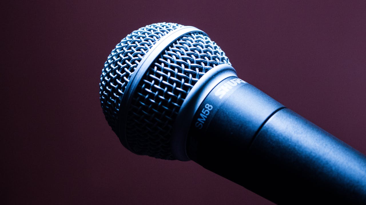 Services-03 A detailed close-up of a Shure SM58 microphone with an artistic blue lighting effect.