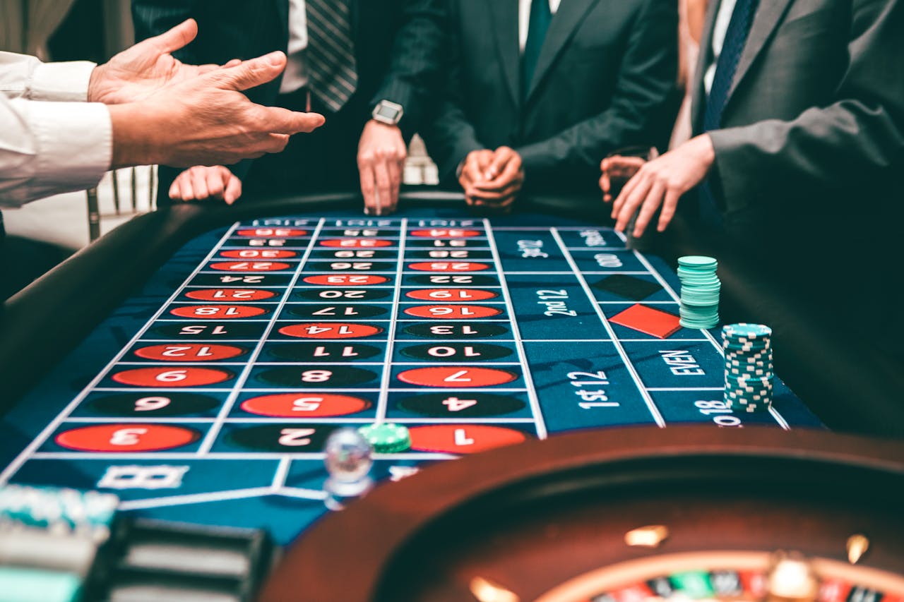 Services-02 Group of people playing roulette, placing bets in a casino setting.